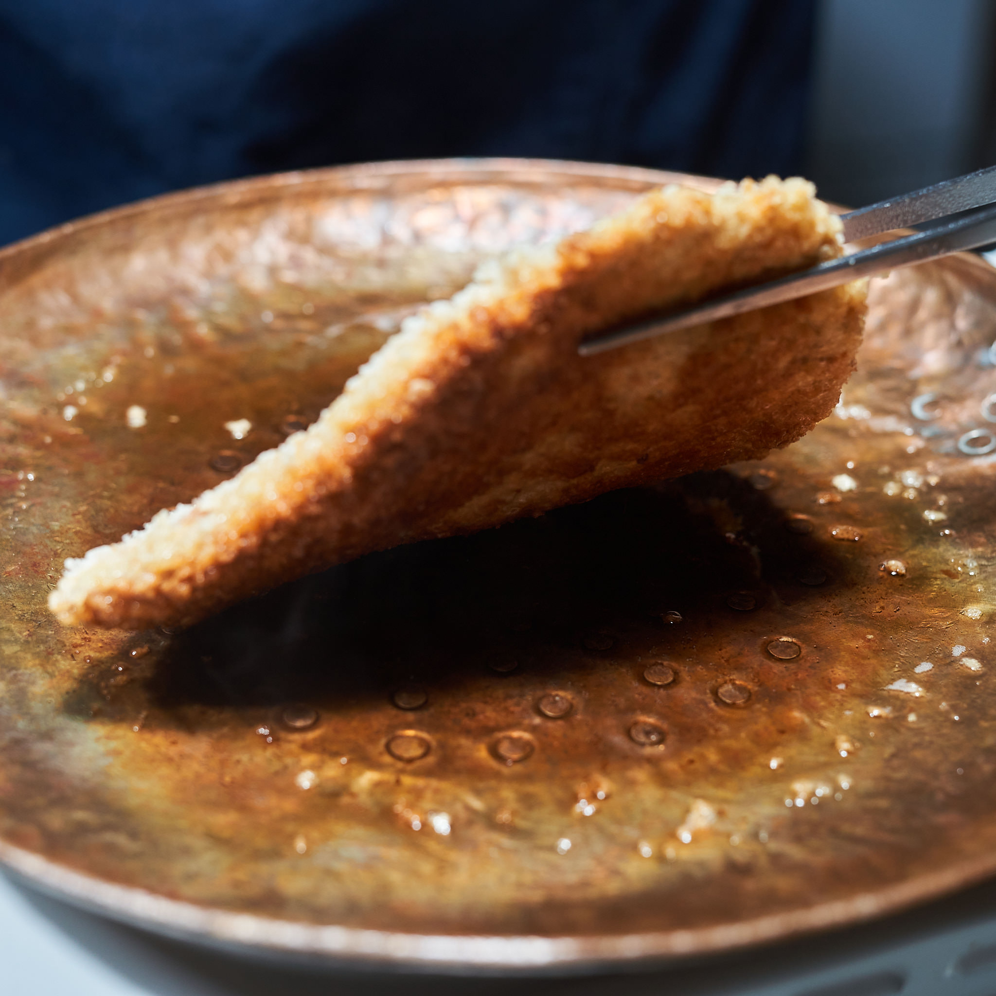 Kaiserschnitzel von der Schale Paniertes Kaiserschnitzel von der Schale wird in der Pfanne gewendet