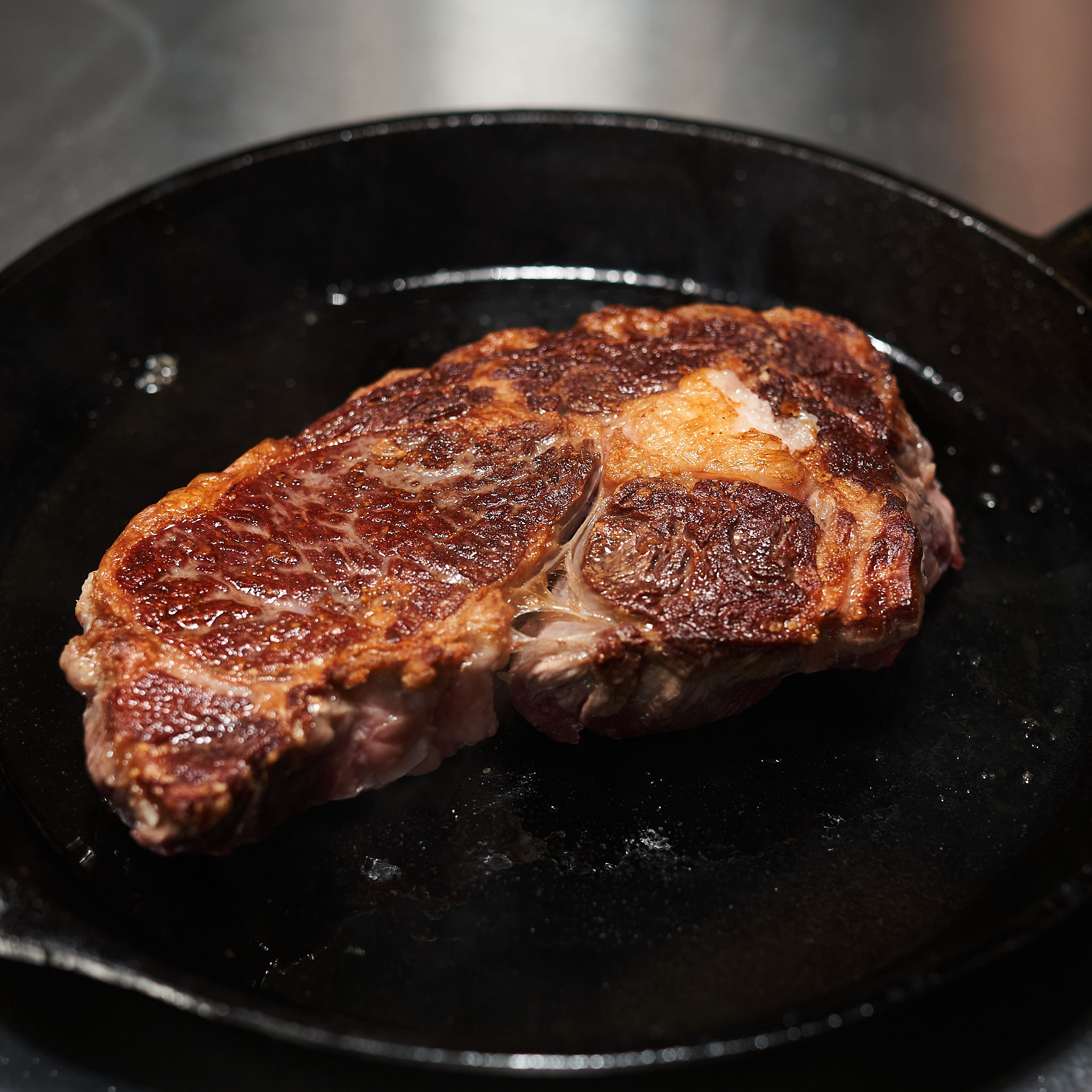 Rib Eye Steak wird in Gusseisenpfanne gegrillt