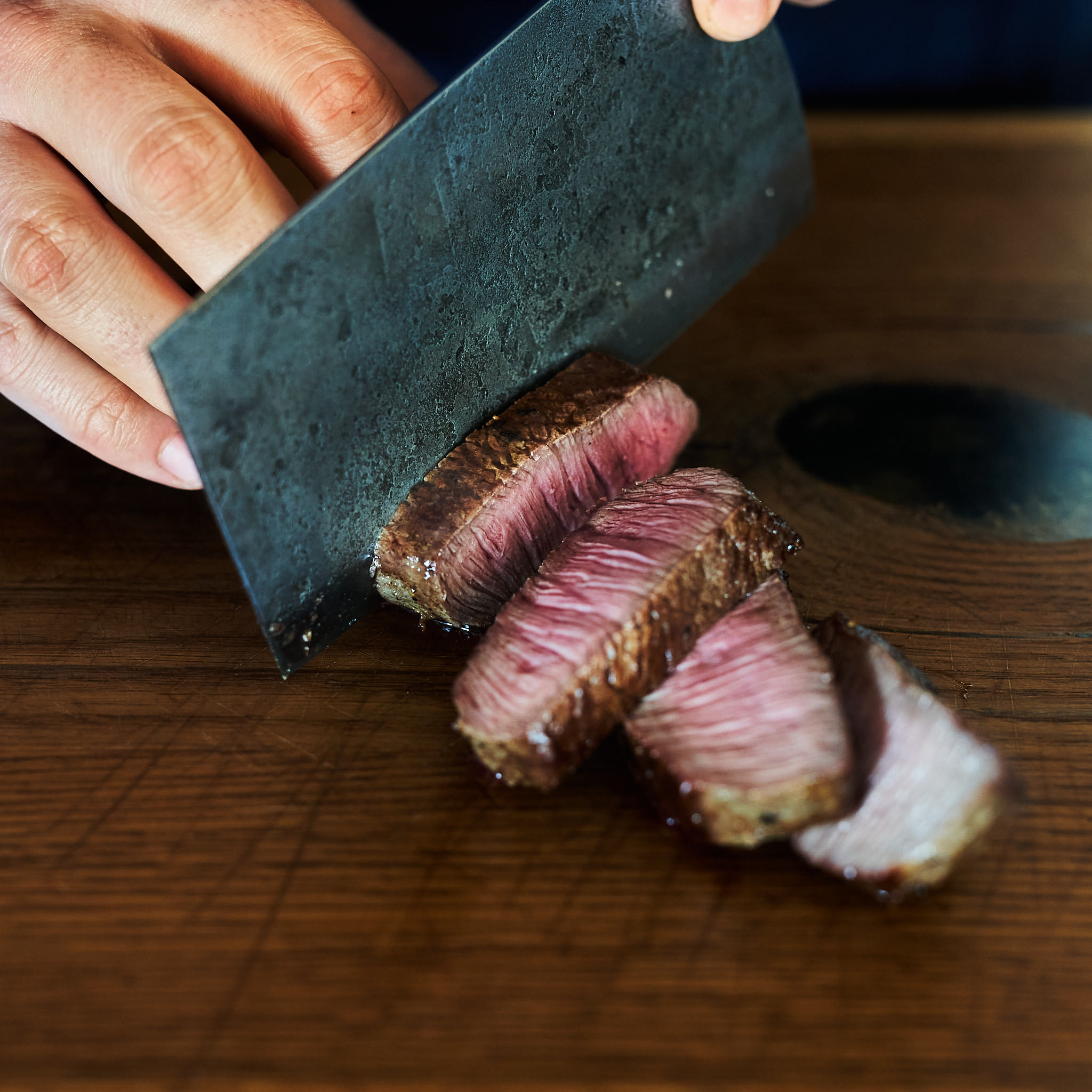 Hueftsteak von der oesterreichischen Kalbin Gegrilltes Hueftsteak wird tranchiert