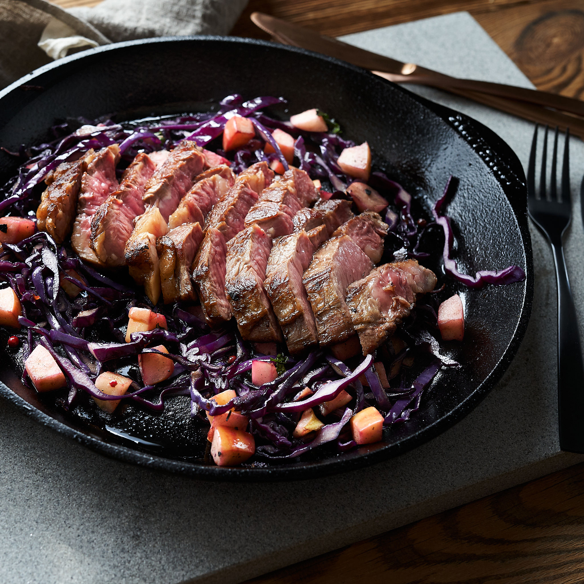 Chuck Steak von der oesterreichischen Kalbin Tranchiertes Chuck Steak auf Rotkraut