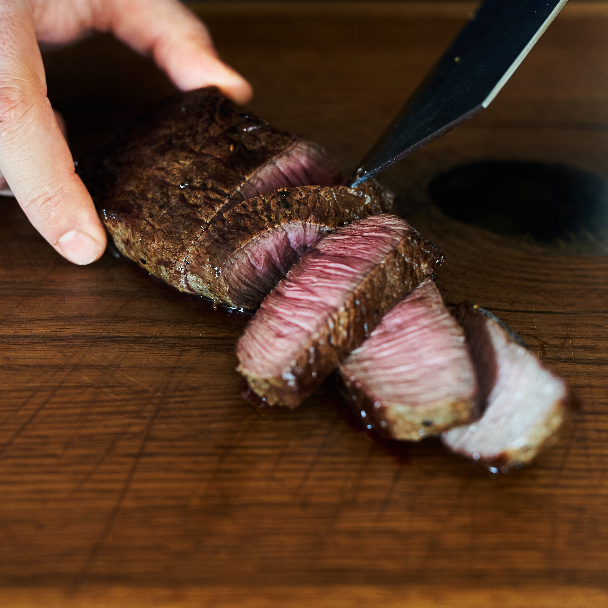 Hueftsteak von der oesterreichischen Kalbin Gegrilltes Hueftsteak wird tranchiert