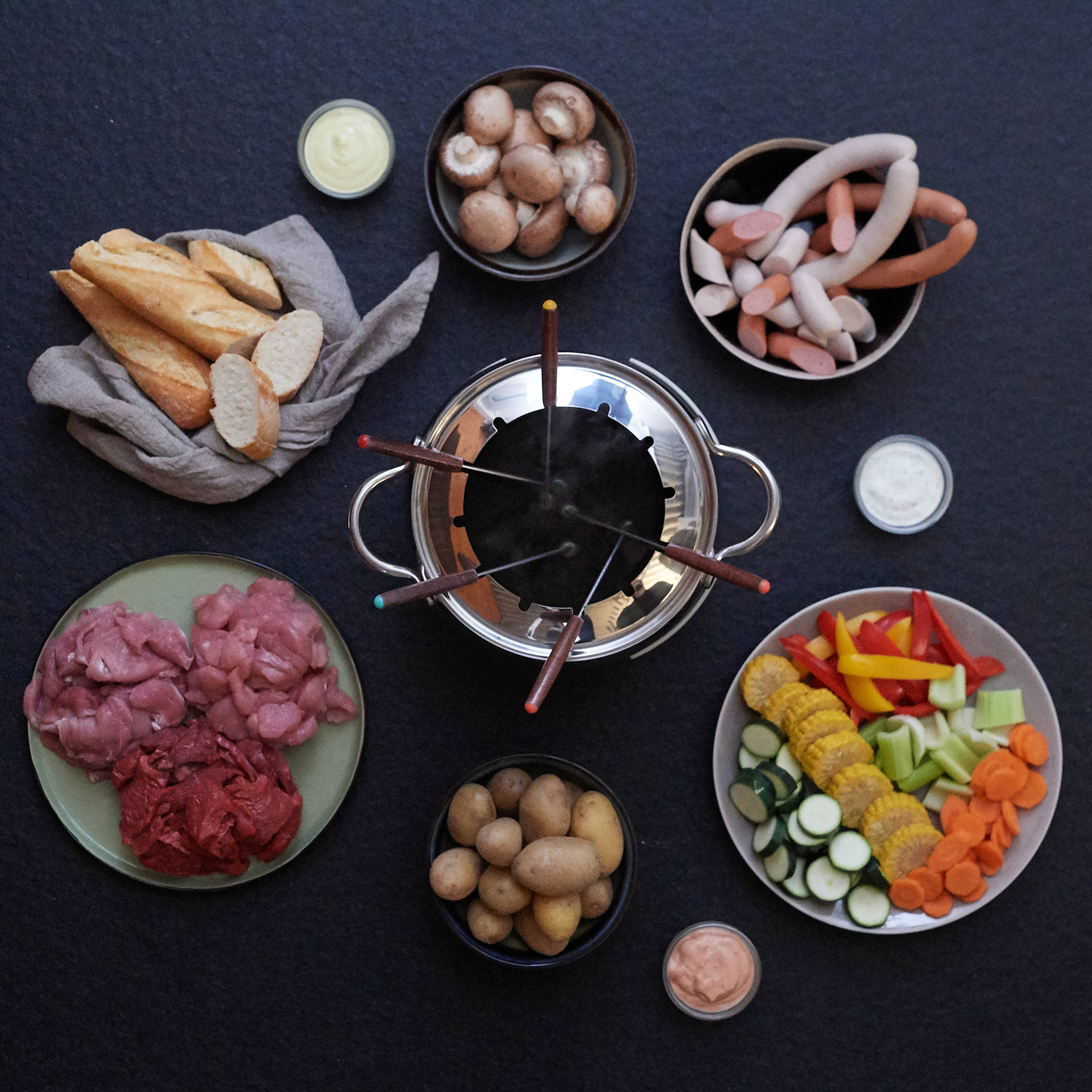 Genussbox Fondue-Platte von Fitmeat Fondueplatte von Fitmeat Genussbox mit Huhn, Schwein, Pute und Würstel serviert mit  Gemuese und Kartoffeln
