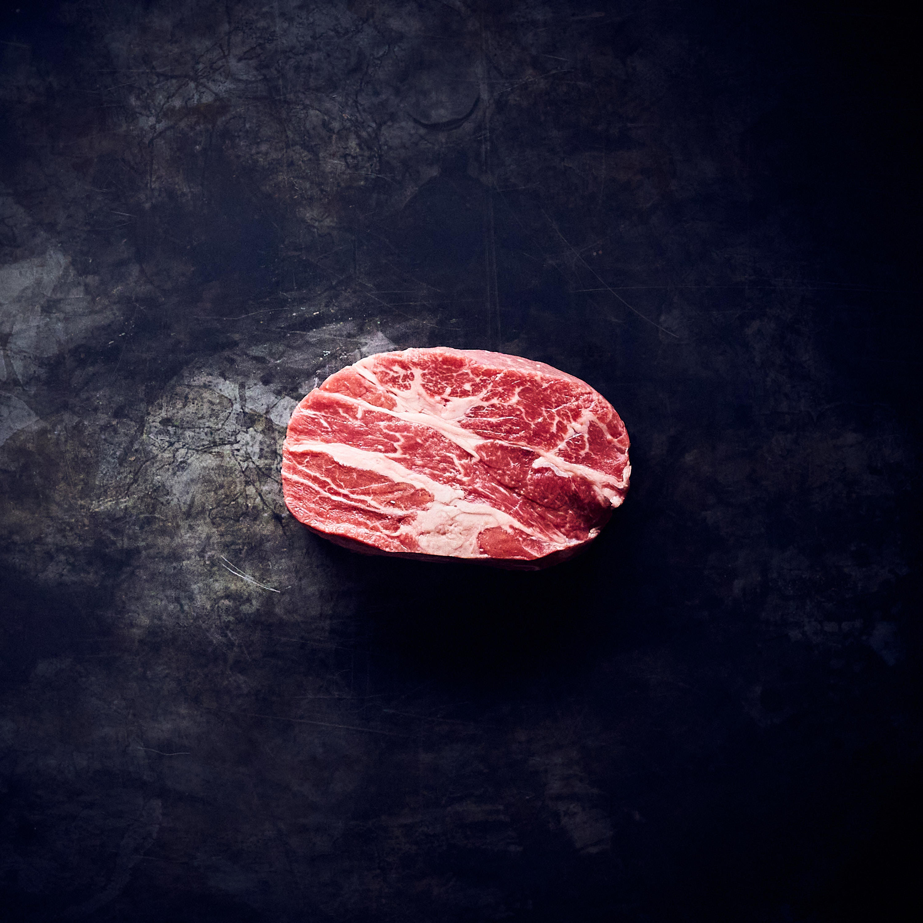 Black Label Chucksteak  Black Label Chucksteak auf schwarzem Marmorhintergrund