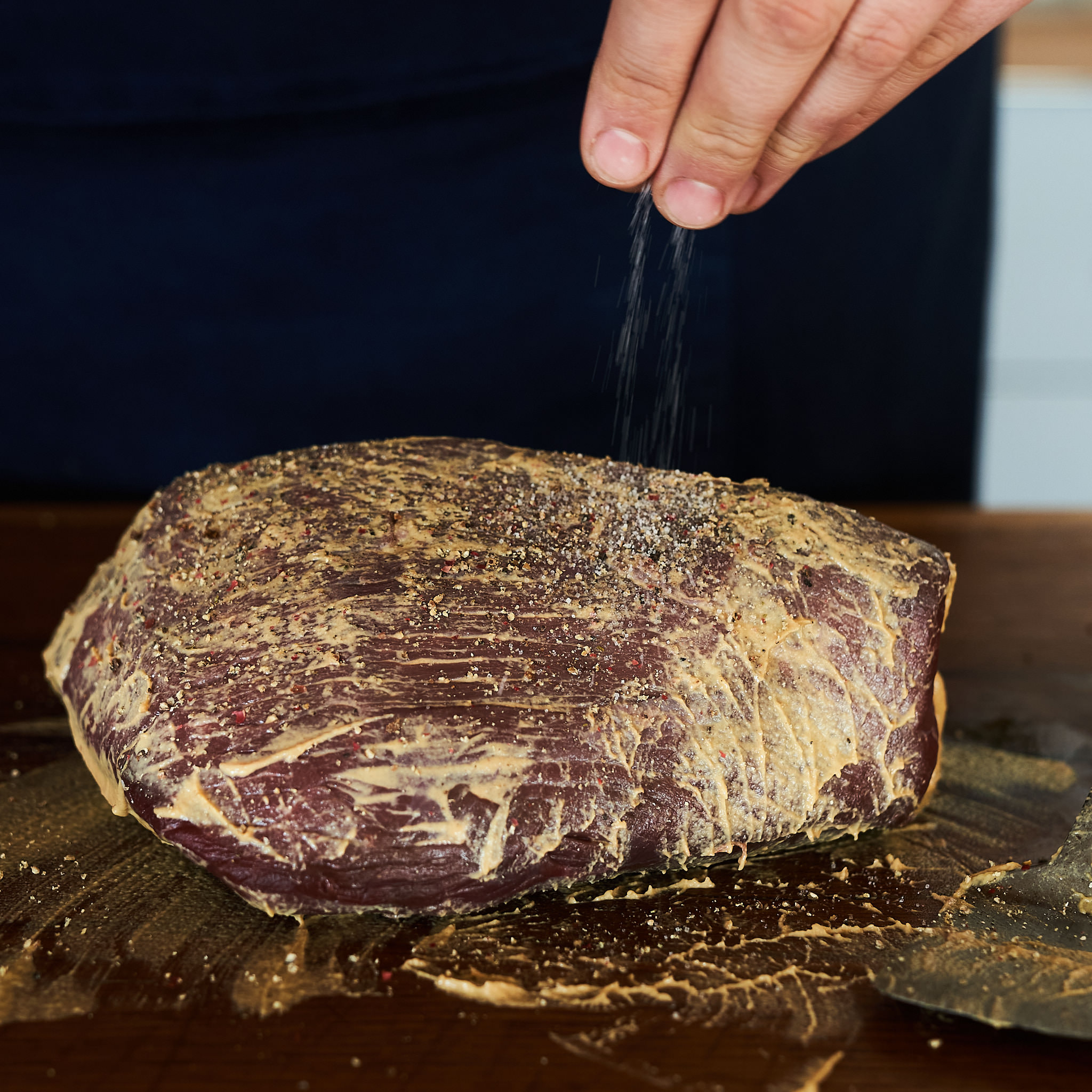 Mit Senf bestrichenes Schwarzes Scherzl wird mit Salz verfeinert