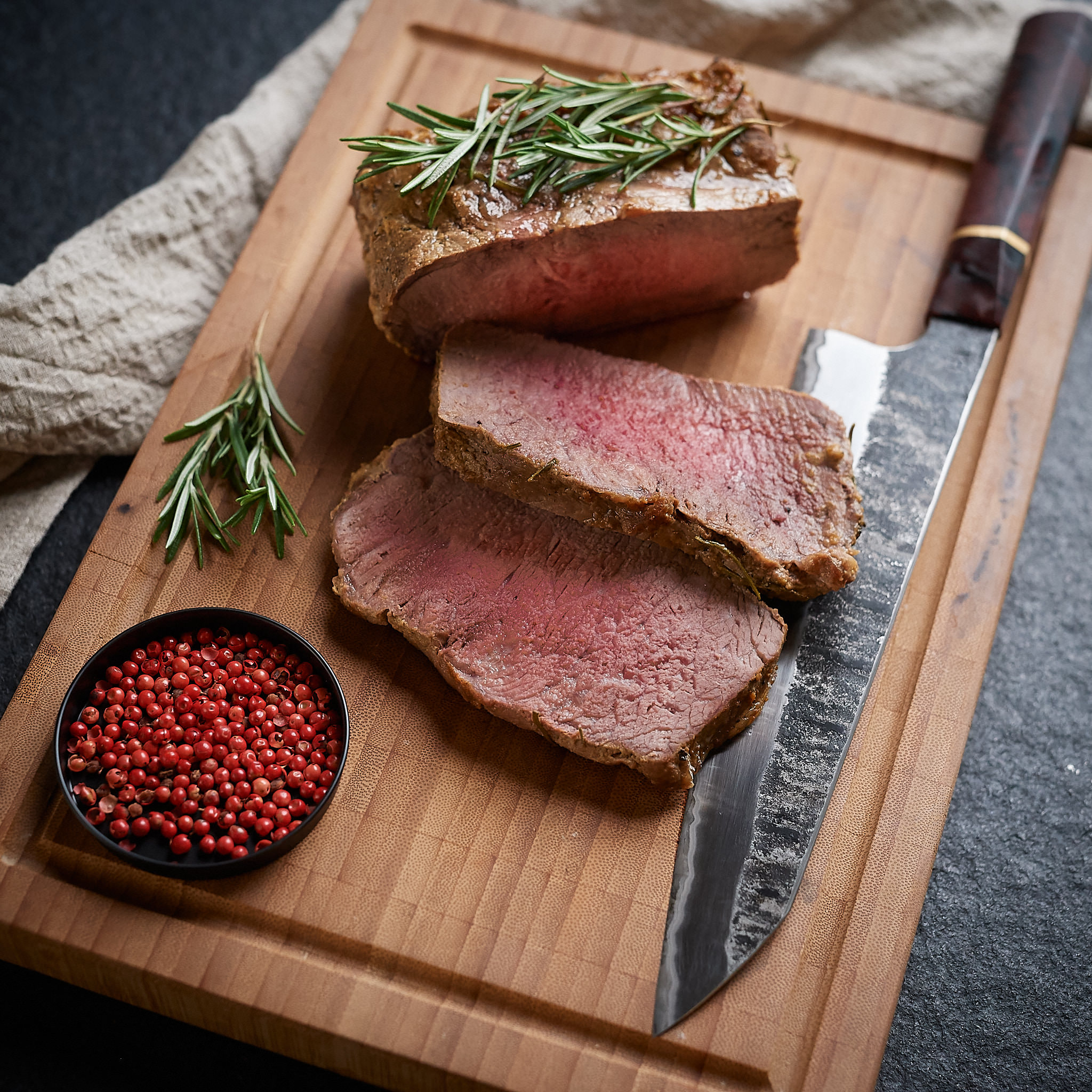 Rumpsteak - Beiried von der oesterreichischen Kalbin Gegrilltes Rumpsteak mit frischem  Rosmarin serviert auf Holzbrett von Fitmeat