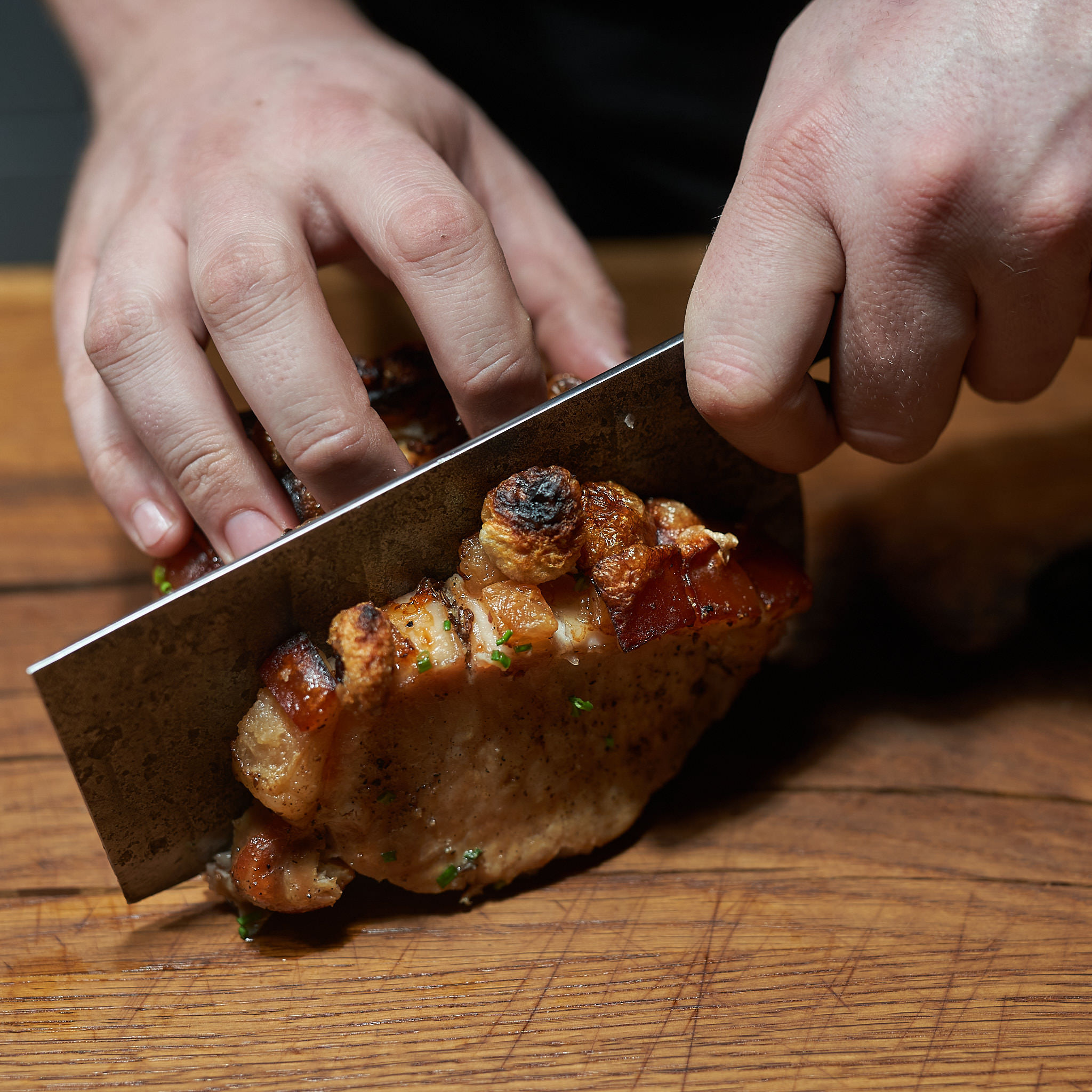 Schweinebraten aus der Schulter – unser Fitmeat Bradl Karree mit Schwarte wird angeschnitten
