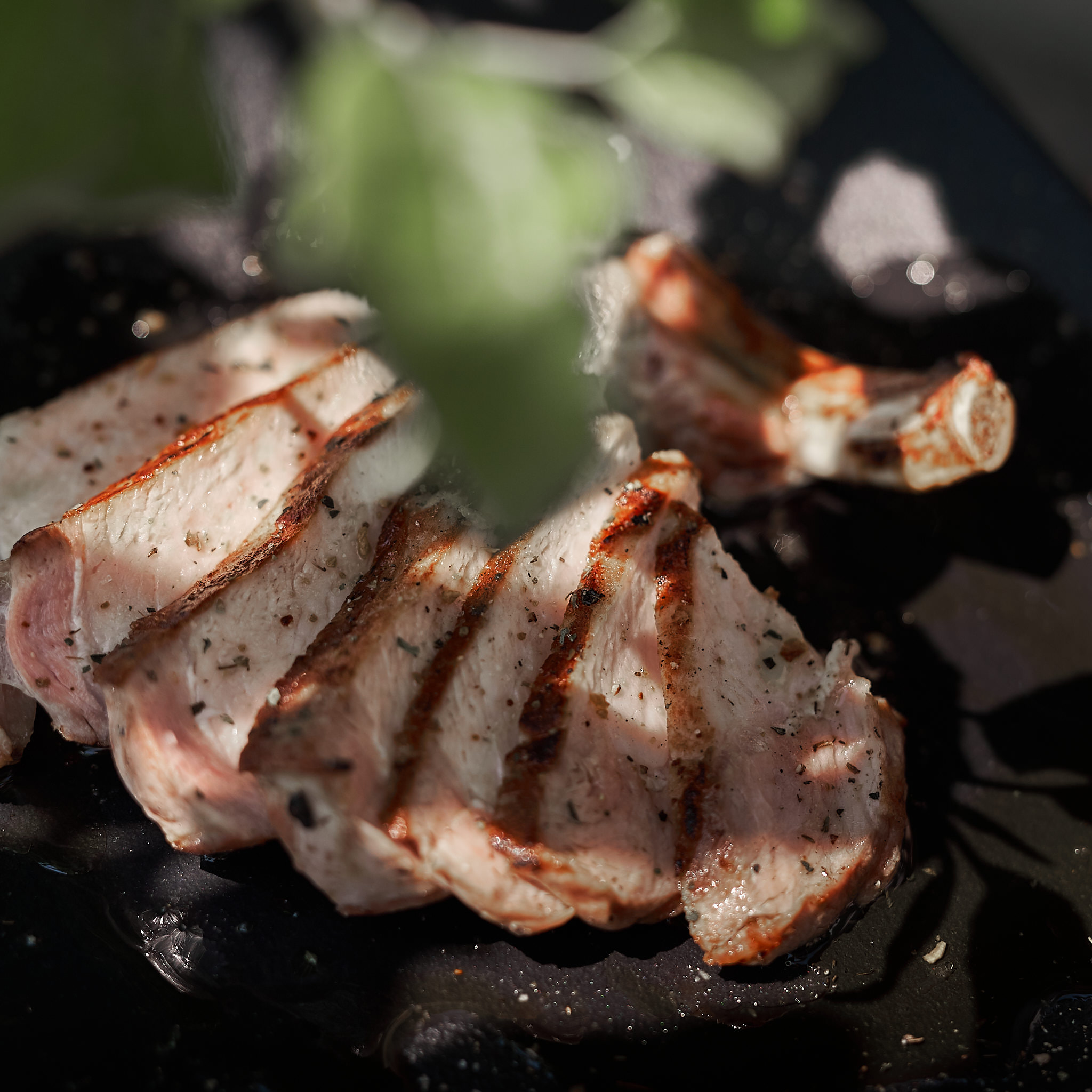 Kotelettes vom Strohschwein Gegrilltes Kotelette vom Strohschwein auf Teller serviert und fein aufgeschnitten