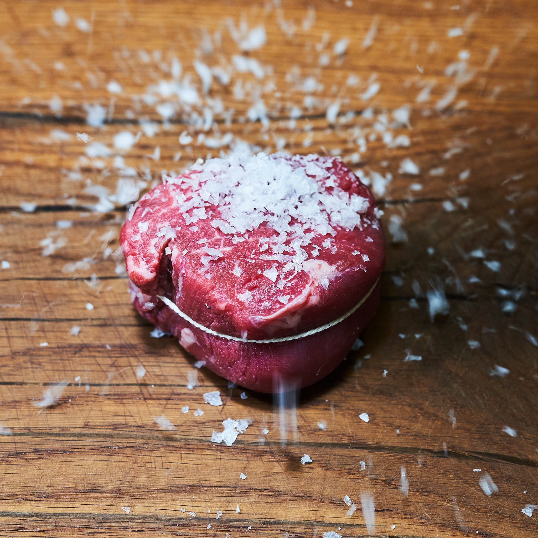 Gebundenes Rinderfilet wird mit Meersalz verfeinert