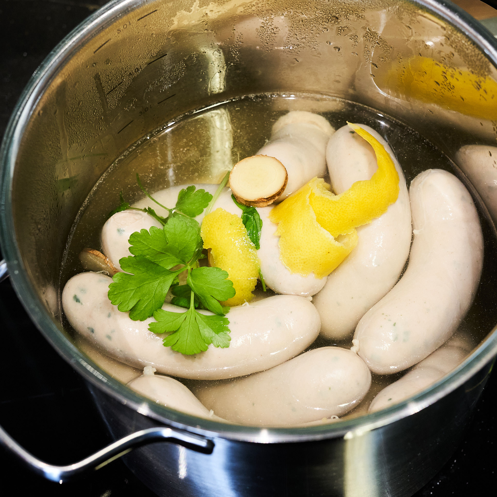 Weisswürstel werden im Kochtopf zubereitet