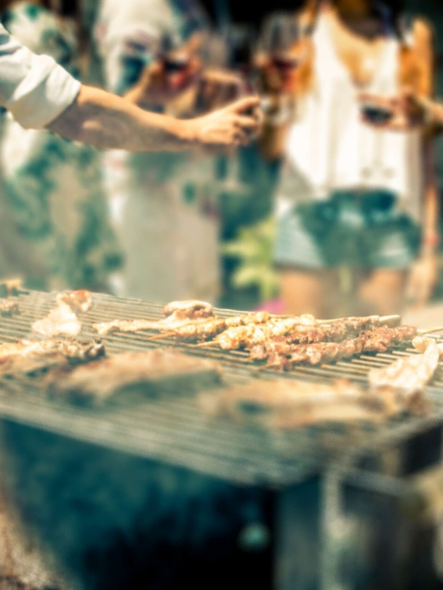 Fleischstuecke werden auf dem Grill zubereitet