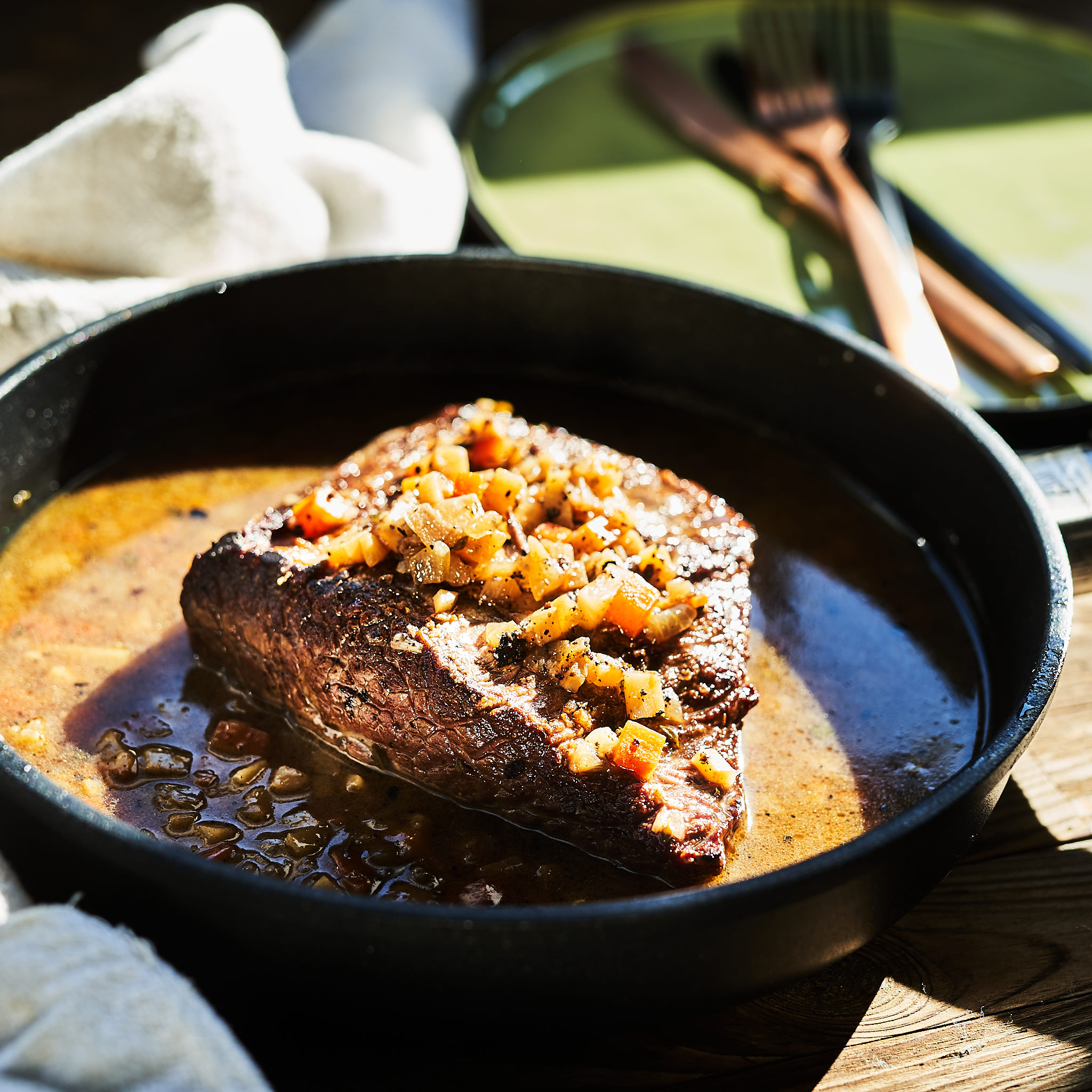 Schwarzes Scherzl in der Pfanne serviert mit Bratensauce und Gemuese