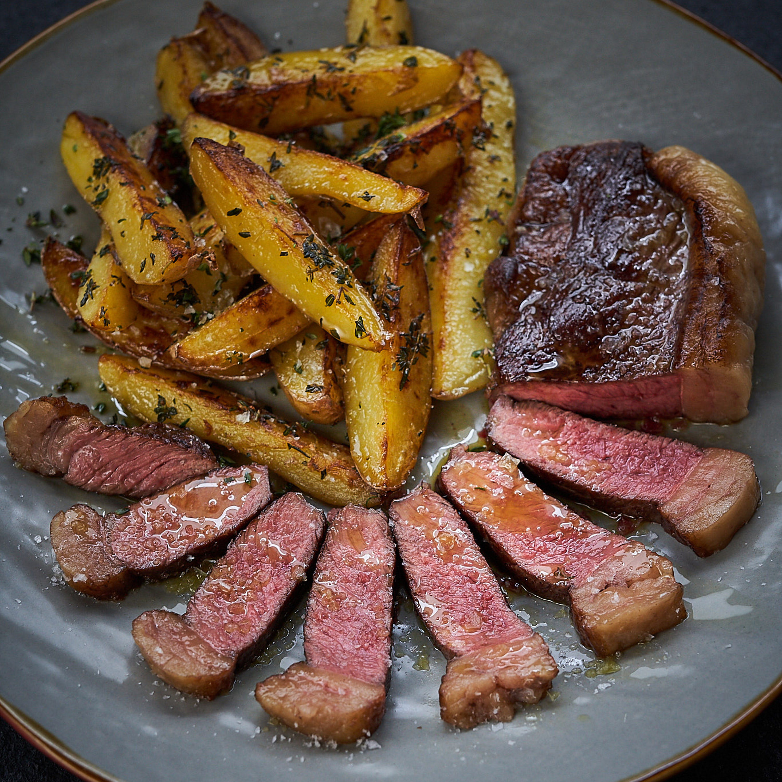 Dry-Aged Rumpsteak mit rosa Kern serviert mit Steak-Fries Dry-Aged Rumpsteak mit rosa Kern serviert mit Steak-Fries