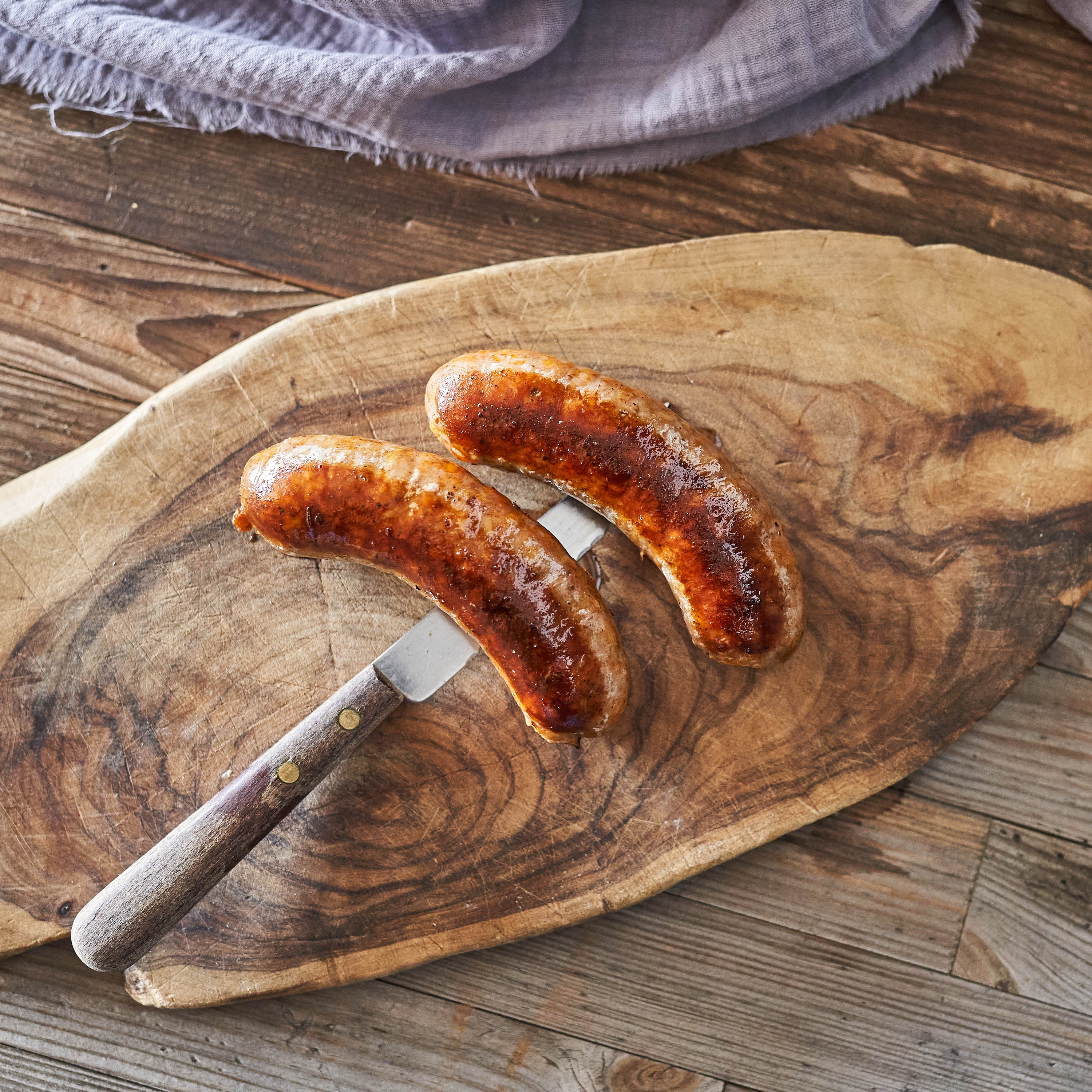 Lungauer Bratwürstel vom Metzgermeister Lungauer Bratwürstel gegrillt und auf Holzbrett serviert