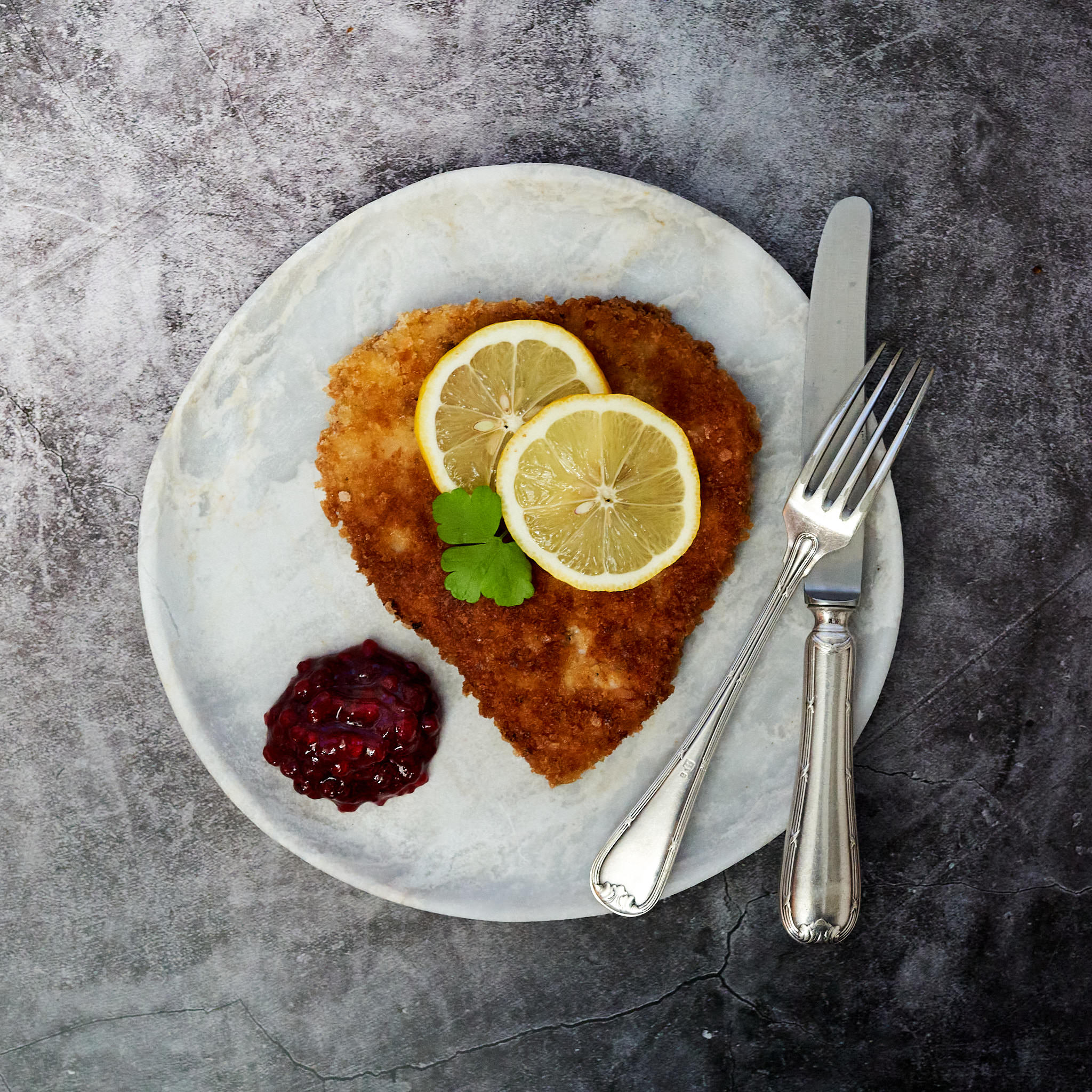 Kaiserschnitzel von der Schale Kaiserschnitzel von der Schale paniert und in Herzform mit zwei Zitronenscheiben serviert